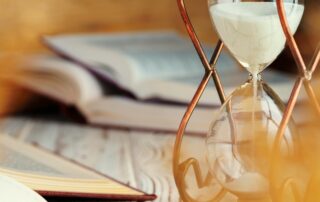 Hourglass with sand close up on wooden background
