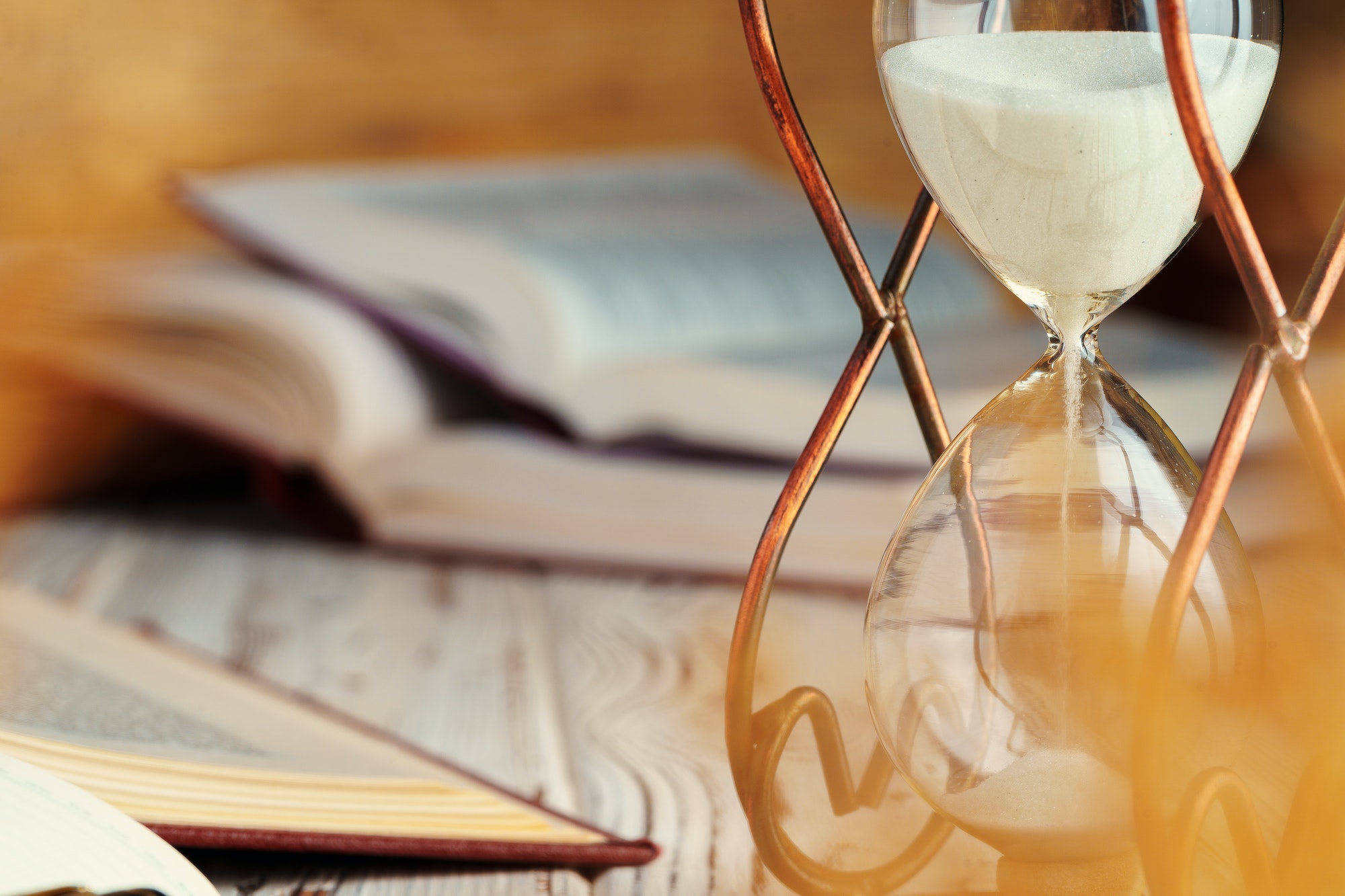 Hourglass with sand close up on wooden background
